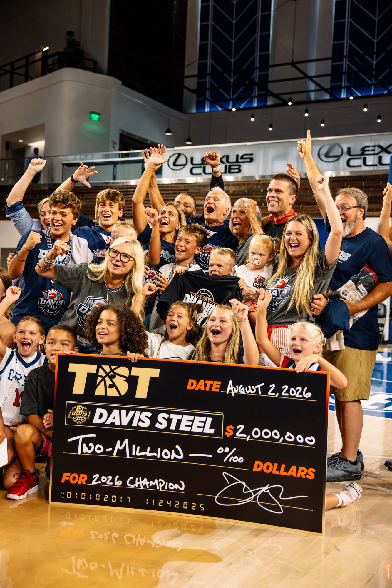 Families, kids and fans celebrating on the floor behind the $2,000,000 championship check.