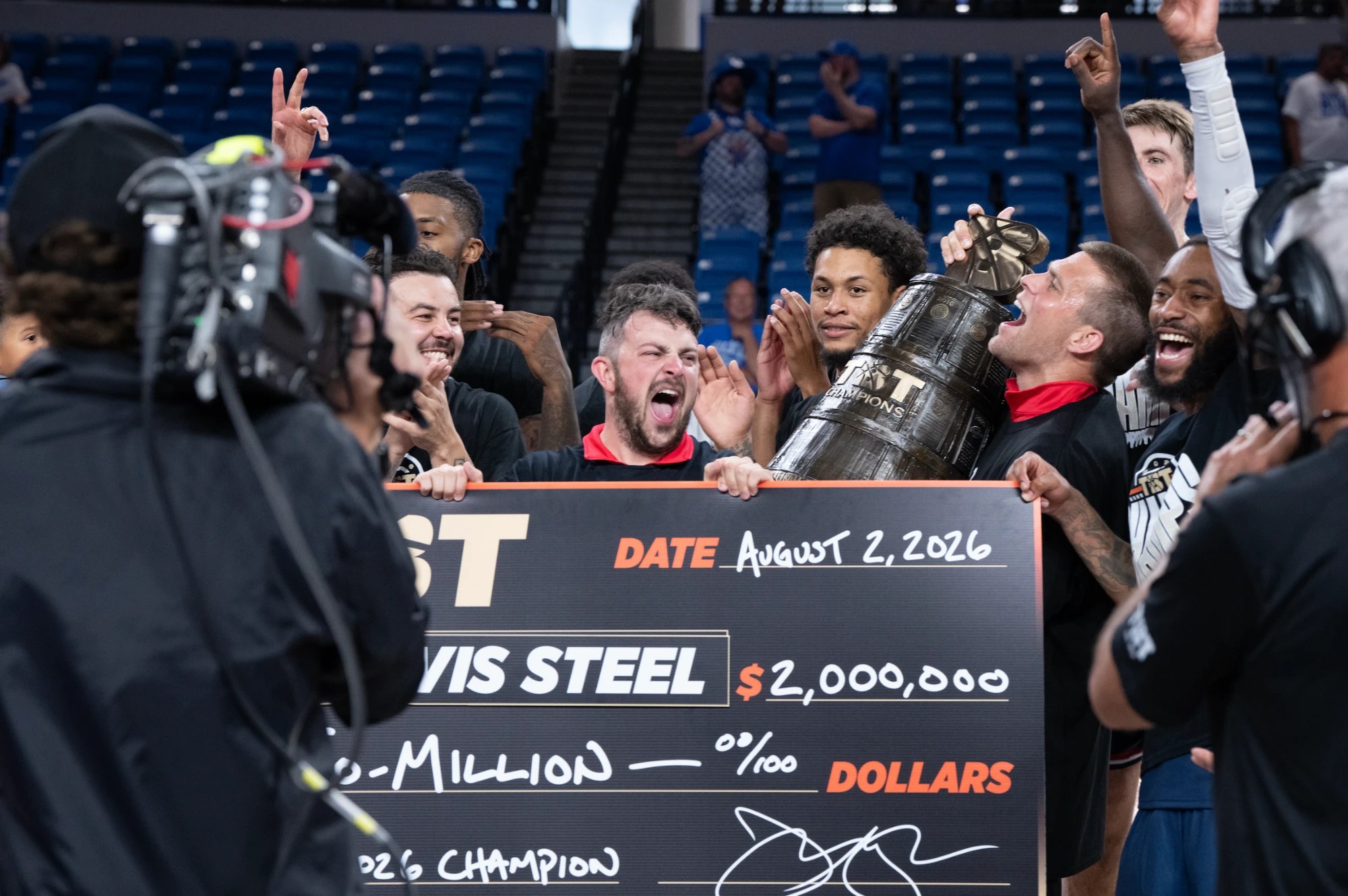 Davis Steel players and staff celebrating around the TBT trophy and the $2,000,000 check after winning the 2026 championship.