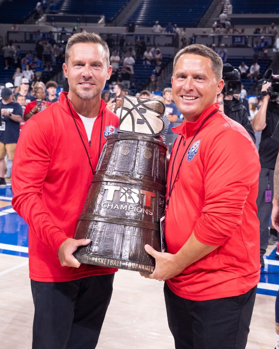 Ashley and Adam Davis in Davis Steel red quarter-zips, holding the TBT championship trophy.
